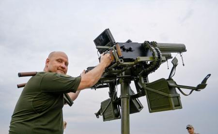 機関銃を構えるビタリー・ズイエフさん=7月、キーウ(共同)