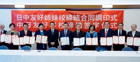 友好姉妹校締結の調印を終え、記念写真に納まる日中の校長ら=15日、北京の日本大使館(共同)