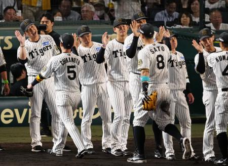 　ＤｅＮＡに勝利し、近本（５）らを迎える阪神・藤川監督（左端）＝甲子園