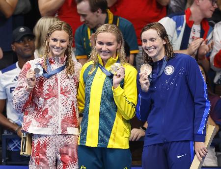 パリ五輪の女子400メートル自由形で金メダルを獲得したオーストラリアのアリアーン・ティトムス(中央)。右は米国のケイティ・レデッキー=2024年7月(共同)