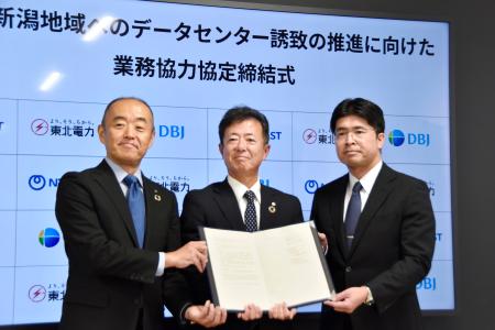 業務協力協定を締結し、写真に納まる東北電力の佐々木秀明常務執行役員（中央）ら＝１６日午前、仙台市