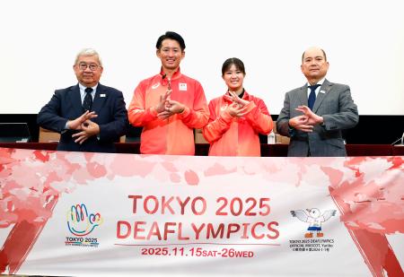 記者会見でポーズをとる(左から)日本選手団の太田陽介団長、旗手の松元卓巳、小倉涼、全日本ろうあ連盟の石橋大吾理事長=16日、東京・内幸町の日本記者クラブ
