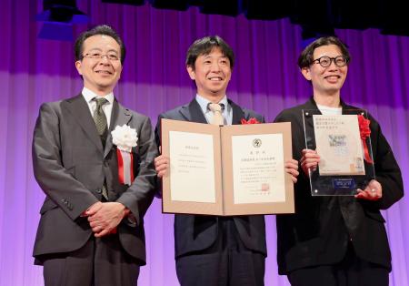 第４５回新聞広告大賞を受賞したアサヒビールの古沢毅氏（中央）。左は日本新聞協会の中村史郎会長＝１６日午後、東京都内