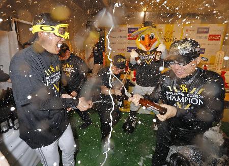 　パ・リーグ優勝の祝勝会でビールをかけあうソフトバンクの小久保監督（左）と孫正義オーナー＝９月、東京都立川市