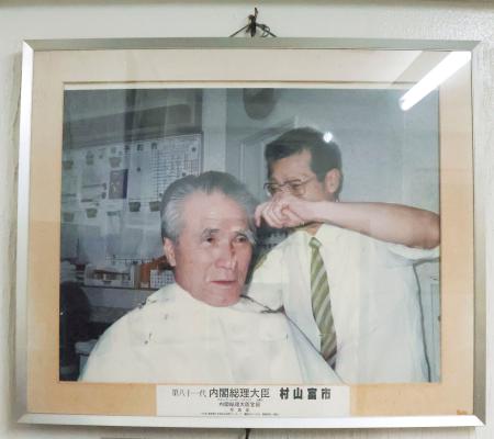 村山富市元首相が通っていた理容室に飾られている写真=17日午後、大分市