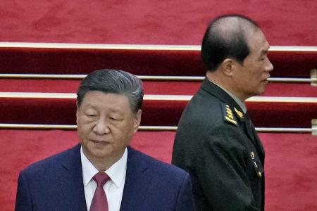 ３月、中国の習近平国家主席（左）と何衛東・中央軍事委員会副主席＝北京の人民大会堂（共同）