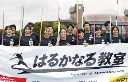 やり投げ教室を終え、参加した高校生たちと記念写真に納まる北口榛花(中央)=等々力補助競技場