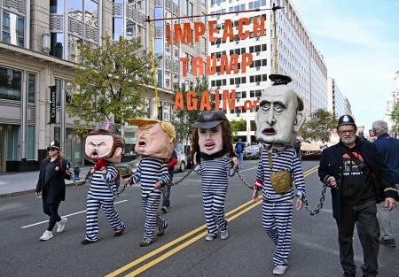 　米ワシントンで「トランプを再び弾劾訴追せよ」と書かれたメッセージを掲げるデモ参加者たち＝１８日（共同）