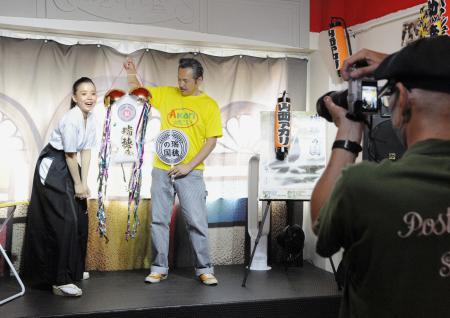 　男性ファンが持参したくす玉を割る山西アカリさん（左）＝東京都台東区