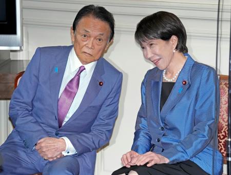 自民党の両院議員総会で麻生太郎副総裁(左)と話す高市早苗総裁=21日午前11時25分、国会