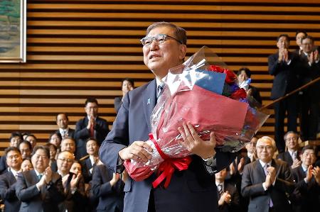 花束を手に首相官邸を去る石破茂首相＝２１日午後０時２８分