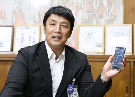 自身のスマートフォンを手に、インタビューに答える愛知県豊明市の小浮正典市長=9月、豊明市役所