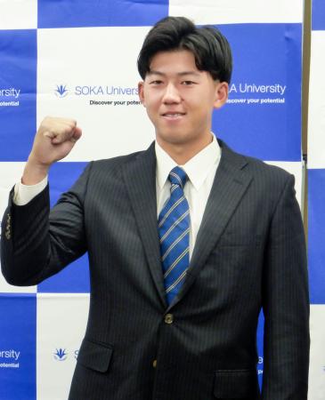 阪神からの指名あいさつを受け、ガッツポーズする創価大の立石正広内野手=24日、東京都八王子市