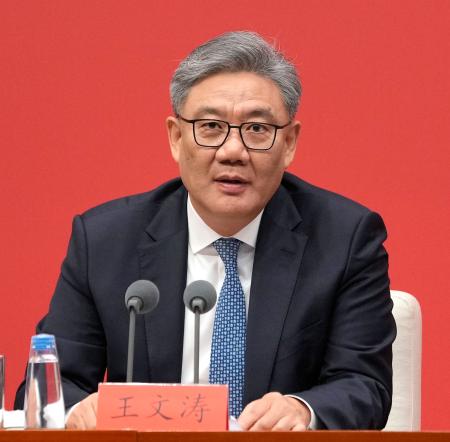 記者会見する中国の王文濤商務相=24日、北京(共同)