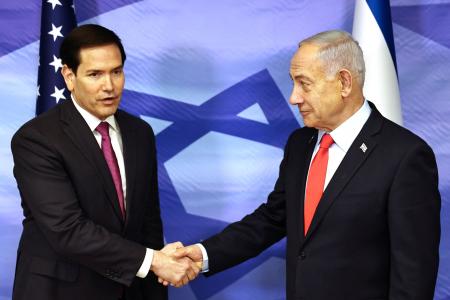 握手するルビオ米国務長官(左)とイスラエルのネタニヤフ首相=23日、エルサレム(ロイター=共同)