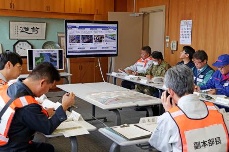 SNS投稿を基に災害時の住民の避難状況を確認する北海道北斗市職員ら=25日、北海道北斗市