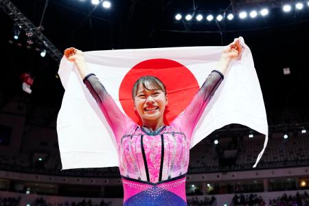 体操の世界選手権女子種目別の床運動で優勝し、日の丸を掲げる杉原愛子=25日、ジャカルタ(共同)