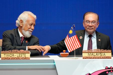26日、東ティモールのグスマン首相(左)にあいさつするマレーシアのアンワル首相=クアラルンプール(AP=共同)