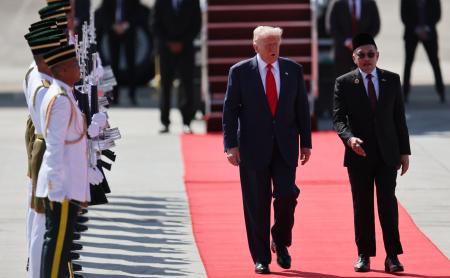 26日、マレーシア・クアラルンプールの空港に到着したトランプ米大統領(中央)と共に歩くマレーシアのアンワル首相(右)(AP=共同)