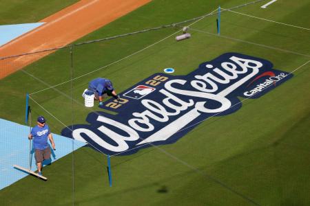 ドジャースの本拠地でワールドシリーズのロゴの作業をする人たち=26日、ロサンゼルス(ゲッティ=共同)