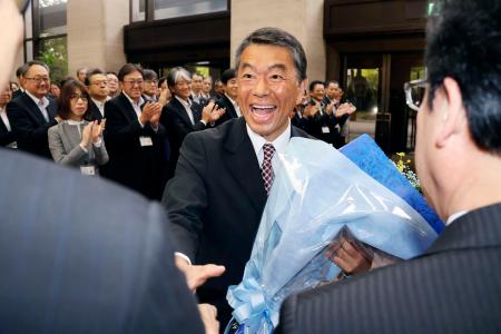 宮城県知事選で６選を果たし、職員と握手する村井嘉浩知事＝２７日午前、県庁