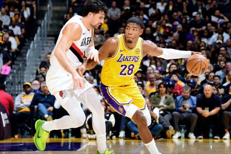 トレイルブレーザーズ戦でプレーするレーカーズの八村(右)=ロサンゼルス(NBAE・ゲッティ=共同)