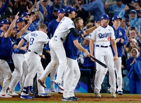 米大リーグ、ブルージェイズとのワールドシリーズ第3戦の18回、サヨナラ本塁打を放ったフリーマンを迎えるため本塁で待ち構えるドジャースの選手たち。右端は佐々木朗希、中央左は大谷翔平=27日、ロサンゼルス(共同)