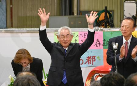 北海道寿都町長選で７選を果たし、万歳して喜ぶ現職の片岡春雄氏＝２８日夜、寿都町