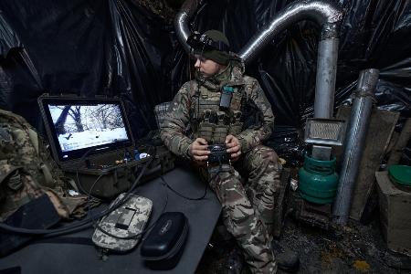 昨年1月、ウクライナ東部ハリコフ州クピャンスクの前線で自爆型無人機を操縦するウクライナ軍兵士(ゲッティ=共同)