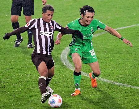 ザンクトパウリの藤田(左)と競り合うボルシアMGの町野=ハンブルク(共同)