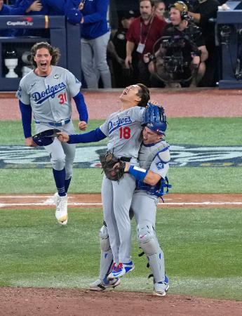 米大リーグ、ブルージェイズとのワールドシリーズ第７戦を制して２連覇を達成し、捕手スミスに抱きかかえられるドジャースの山本由伸＝２日、トロント（共同）