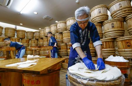 京都市左京区の老舗漬物店「大安」で公開された「千枚漬」の漬け込み作業＝７日午前