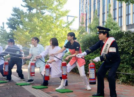 東京消防庁の一日消防署長を務め、訓練で消火器を噴射する俳優の鈴木福さん（右端）＝７日午前、東京都新宿区