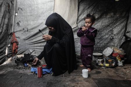 ６日、ガザ中部デールバラハのテントで避難生活を送る女性と子ども（ゲッティ＝共同）