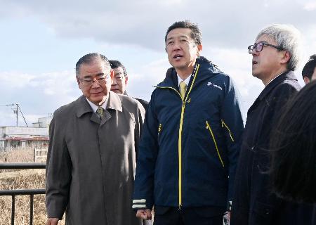 納沙布岬から北方領土・歯舞群島を視察する黄川田沖縄北方相（中央）＝８日午後、北海道根室市