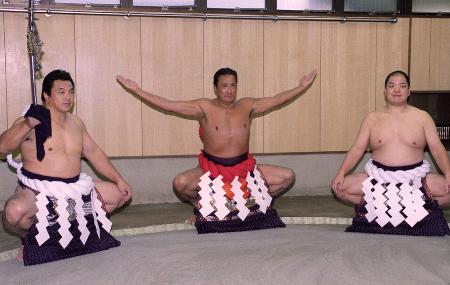 ２００１年、赤い横綱を締め還暦土俵入りの練習をする元横綱の北の富士さん（中央）。左は九重親方（元横綱千代の富士）、右は八角親方（元横綱北勝海）＝東京都墨田区の八角部屋