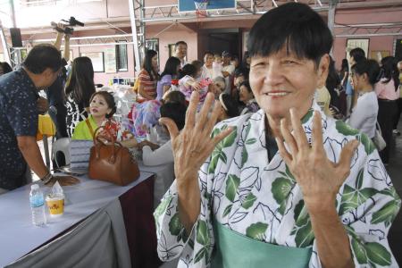 日系人会の集会で、浴衣姿で日本人ネイリストに塗ってもらった爪を見せるカナシロ・ロサさん＝５月、フィリピン南部ダバオ（共同）