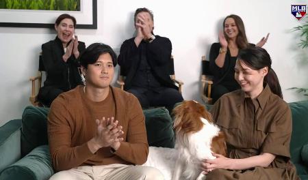 米大リーグ、ナショナル・リーグのMVPに満票で選ばれ、MLBネットワークの番組で喜ぶドジャースの大谷翔平。右は妻真美子さん=13日