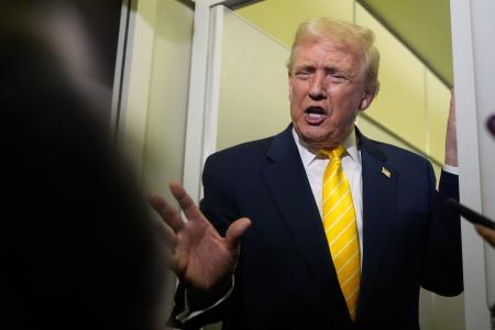 大統領専用機「エアフォースワン」の機内で報道陣の取材に応じるトランプ大統領＝１４日（ＡＰ＝共同）