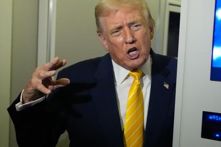 大統領専用機「エアフォースワン」の機内で報道陣の取材に応じるトランプ大統領＝１４日（ＡＰ＝共同）