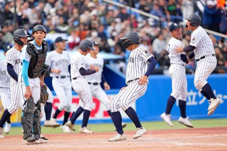 山梨学院戦の９回、菰田の暴投で九州国際大付・吉田（手前右）がサヨナラの生還＝神宮