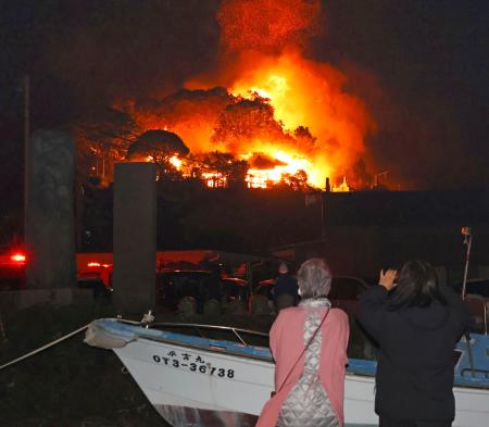 　大分市佐賀関の火災現場を心配そうに見つめる近隣住民＝１８日午後９時４２分
