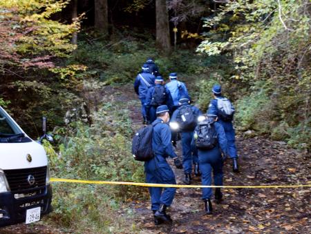 現場に向かう山道に入る警察官ら＝１９日午前１０時４５分、福岡県八女市