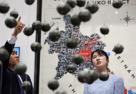 ＣＯＰＥビジターセンターでクラスター弾に関する展示を視察される愛子さま＝１９日、ビエンチャン（代表撮影・共同）