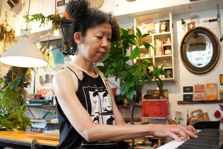 行きつけのカフェでピアノを弾く稲垣えみ子=東京都目黒区のUnder the mat