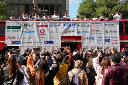 大阪・御堂筋で行われたセ・リーグ優勝記念パレードで、ファンに手を振る阪神の選手ら＝２２日午前