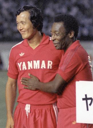 1984年8月、引退試合を終えペレさん(右)からねぎらいを受ける釜本邦茂さん=国立競技場