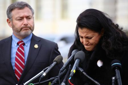 記者会見で涙ぐむハナンさん（右）＝２１日、米ワシントン（共同）