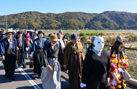 　「１０００人の金田一耕助」と銘打ったイベントで、登場人物に仮装してゆかりの地を練り歩く参加者ら＝２２日午後、岡山県倉敷市