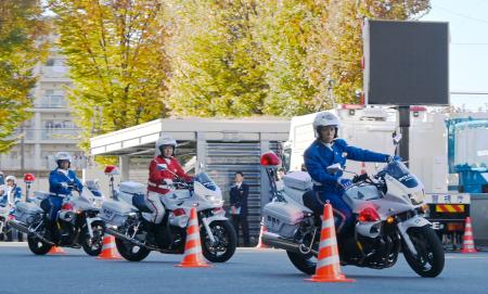 参加者の前で白バイを運転する隊員ら＝２２日午後、東京都目黒区